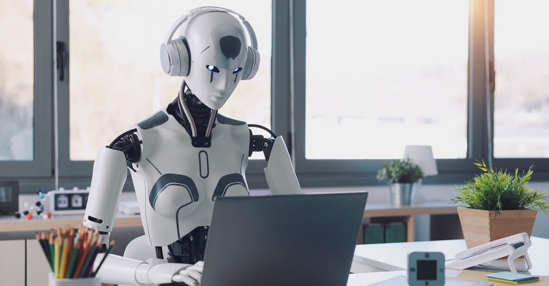 A humanoid robot works in an office on a laptop to listening Music in  Headphone, showcasing the utility of automation in repetitive and tedious tasks.