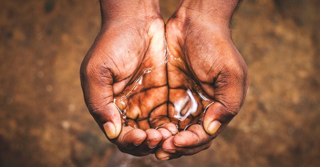 a man holding water in his hand,save water,water crisis in India and worldwide