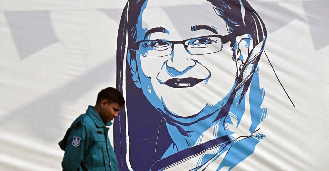 Sheikh Hasina ബംഗ്ലദേശ് പ്രധാനമന്ത്രി ഷെയ്ഖ് ഹസീനയുടെ ചുമർ ചിത്രത്തിനു സമീപത്തു കൂടി നടന്നു പോകുന്ന പൊലീസുകാരൻ. ധാക്കയിൽനിന്നുള്ള ദൃശ്യം (Photo by Indranil MUKHERJEE / AFP)