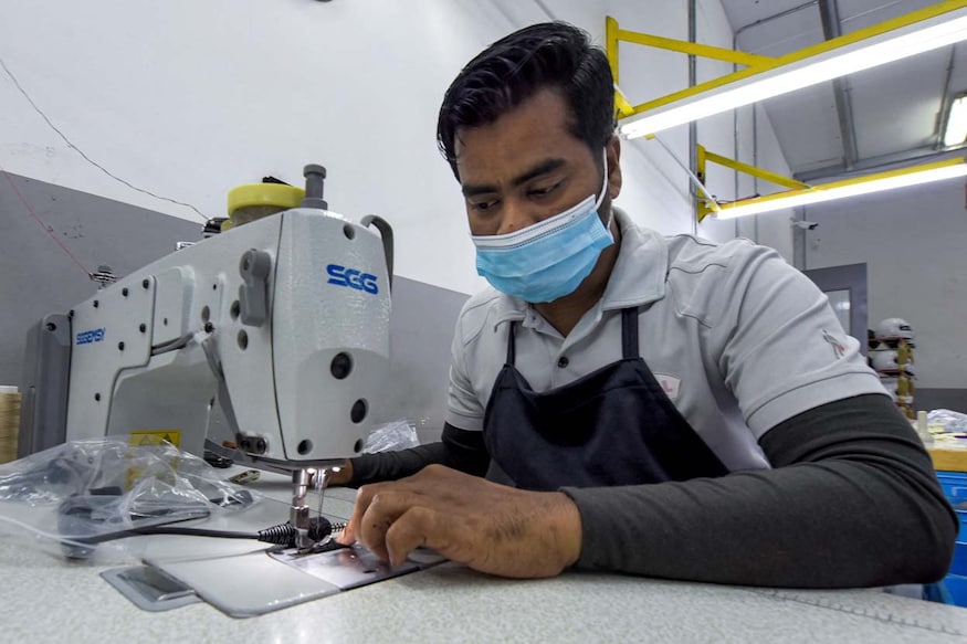 In this picture taken on March 28, 2023 a worker sews fabric at the Racing Force Group helmet factory on the outskirts of Bahrain International Circuit (BIC) in Sakhir in southern Bahrain. The small Gulf kingdom of Bahrain is known worldwide for its prestigious Formula One competitions. In the Sakhir desert in the country's south, enthusiasm for the sport has spread to the industrial sector, with a factory locally manufacturing drivers' helmets. (Photo by Mazen Mahdi / AFP)