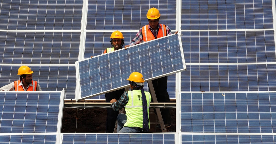 Indian workers give the finishing touches to solar panels at the Gujarat solar park at Charanka village of Patan district, some 250 kms from Ahmedabad on April 14, 2012.  Western India's Gujarat state Chief Minister, Narendra Modi is scheduled to inaugurate the Charanka Solar Park, which has more than 200 MW of installed solar power capacity, on April 19. AFP PHOTO / Sam PANTHAKY (Photo by SAM PANTHAKY / AFP)