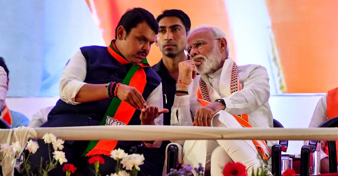 India's Prime Minister Narendra Modi (R) gestures while speaking to Chief Minister of the state Devendra Fadnavis (L) as they attend a public rally in the run up to the Maharashtra state assembly elections, in Mumbai on October 18, 2019. The western Indian state of Maharashtra, currently ruled by an alliance of the Modi led Bharatiya Janata Party (BJP) and right-wing Hindu party Shiv Sena, goes to polls on October 21. (Photo by Indranil MUKHERJEE / AFP)