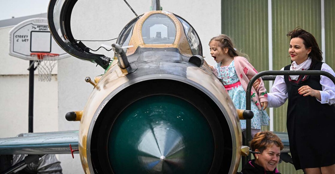 ROMANIA-DEFENCE-AVIATION-MIG-NATO 2023 മാർച്ചിൽ, റുമേനിയൻ വ്യോമപ്പടയിൽനിന്ന് മിഗ്–21 ഒഴിവാക്കുന്ന ചടങ്ങിൽ യുദ്ധ വിമാനം പ്രദർശനത്തിനു വച്ചപ്പോൾ കാണാനെത്തിയവർ (Photo by Daniel MIHAILESCU / AFP)