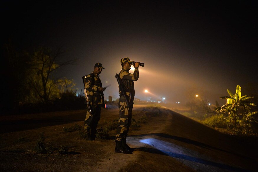 TOPSHOT - In this picture taken on December 30, 2021, Indian Border Security Force (BSF) soldiers patrol along an unfenced area at the India Bangladesh border outpost in Phansidewa village, about 35km from Siliguri. (Photo by Diptendu DUTTA / AFP)