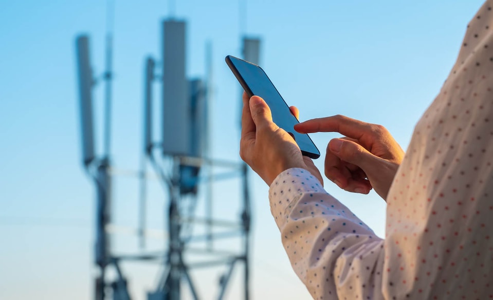 5G communications tower with man using mobile phone