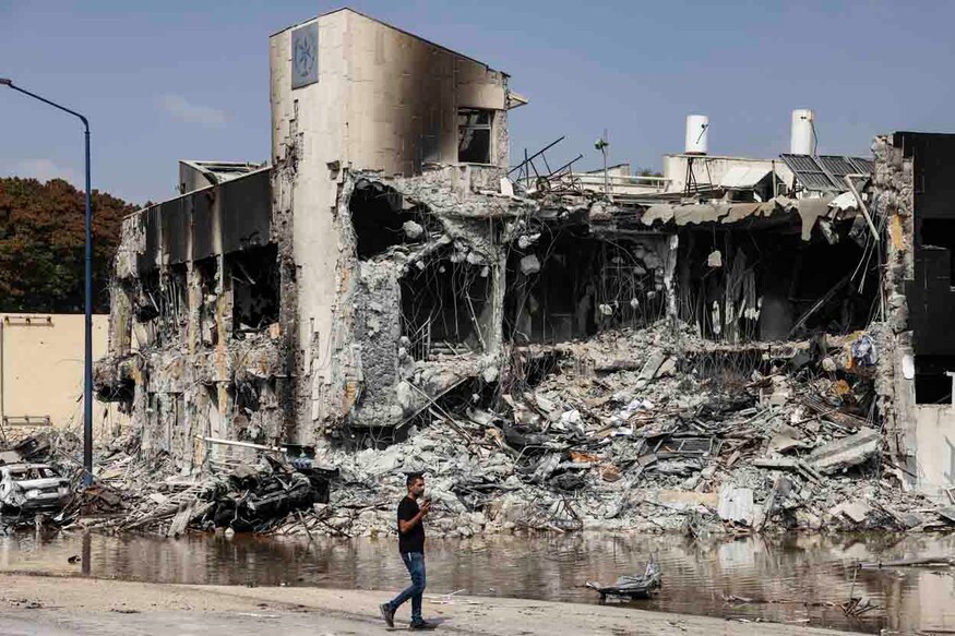 A man walks past an Israeli police station in Sderot after it was damaged during battles to dislodge Hamas militants who were stationed inside, on October 8, 2023. - Israel's prime minister of October 8 warned of a "long and difficult" war, as fighting with Hamas left hundreds killed on both sides after a surprise attack on Israel by the Palestinian militant group. (Photo by RONALDO SCHEMIDT / AFP)