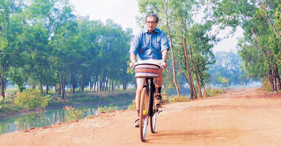 amartya-sen കൊൽക്കത്ത ശാന്തിനികേതനിലെ ബീർഭൂമിയിലൂടെ സൈക്കിളിൽ പോകുന്ന അമർത്യ സെൻ