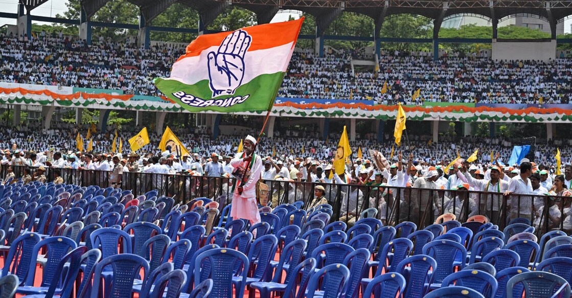 കോൺഗ്രസ് പാർട്ടി പതാകയുമായി പ്രവർത്തകൻ. (Photo by Manjunath KIRAN / AFP)