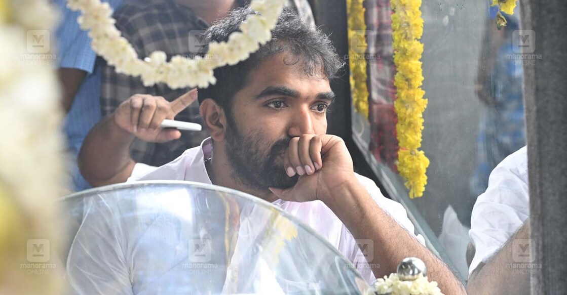 ഉമ്മൻചാണ്ടിയുടെ ഭൗതിക ശരീരം  വഹിച്ച് തിരുവനന്തപുരത്തു നിന്ന് കോട്ടയം പുതുപള്ളി വീട്ടിലേക്കുള്ള  വിലാപയാത്രയിൽ മകൻ ചാണ്ടി ഉമ്മൻ.
(ചിത്രം: മനോരമ)