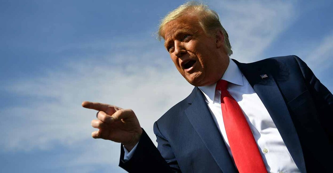 TOPSHOT - US President Donald Trump speaks to members of the media upon arrival at Phoenix Sky Harbor International Airport in Phoenix, Arizona on October 19, 2020. Trump is heading to Prescott, Arizona for a campaign rally. - US President Donald Trump went after top government scientist Anthony Fauci in a call with campaign staffers on October 19, 2020, suggesting the hugely respected and popular doctor was an "idiot." (Photo by MANDEL NGAN / AFP)