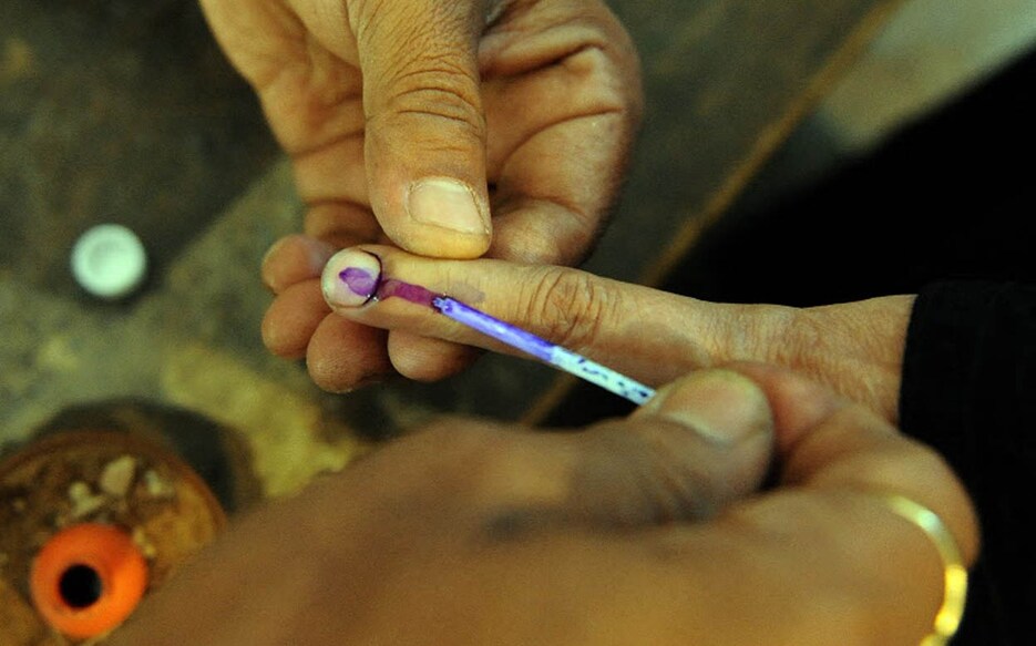 INDIA-POLITICS-VOTE An Indian election officer marks the finger of a voter with ink during the first phase of polling in Varanasi on April 16, 2009. India kicked off month-long elections, with all signs pointing to a splintered result and government by an unsteady coalition that would struggle to see out a full term. AFP PHOTO/Prakash SINGH (Photo by PRAKASH SINGH / AFP)