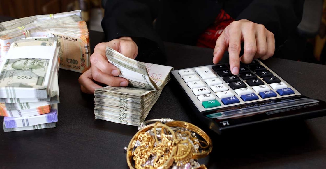 Businesswoman counting money, calculating the conversion rate of Indian Rupee money as a return of financial investment at the table in her office indoors.