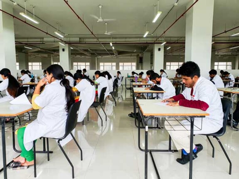 October 30, 2019, Kolkata, India. Medical students writing a medical examination in examination hall wearing white coats during day time at NRS Medical College Kolkata, India.