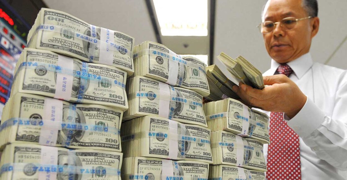 A bank employee holds US dollar bank notes at the Korean Exchange Bank in Seoul on October 7, 2008.  Korea's won fell to an over six-year low on increased concerns that the global credit crunch is deepening as it is exacerbated by slumping stock markets, dealers said. AFP PHOTO/JUNG YEON-JE (Photo by JUNG YEON-JE / AFP)