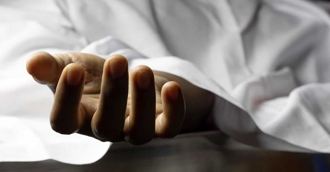 an Indian or Asian person laying dead with outstretched hand during COVID-19 or corona virus outbreak