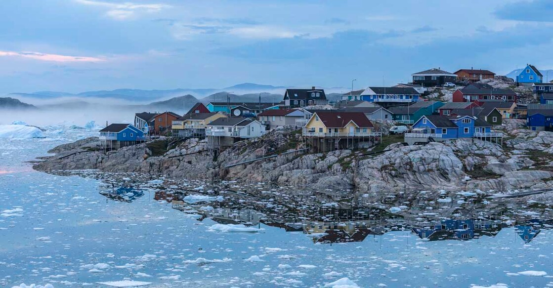 1166141850 View from the end of the Ilulissat Icefjord to the town Ilulissat at the Disko Bay in western Greenland at midnight in July.