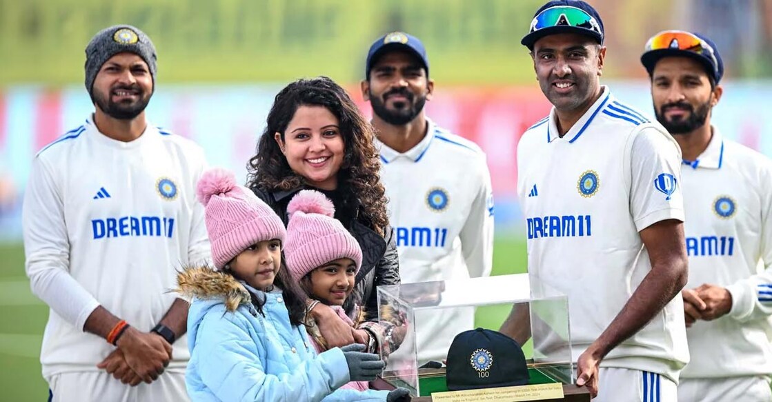 നൂറാം ടെസ്റ്റിന്റെ തൊപ്പിയുമായി ആർ. അശ്വിനും കുടുംബവും. സഹതാരങ്ങൾ സമീപം. (Photo by Sajjad HUSSAIN / AFP)