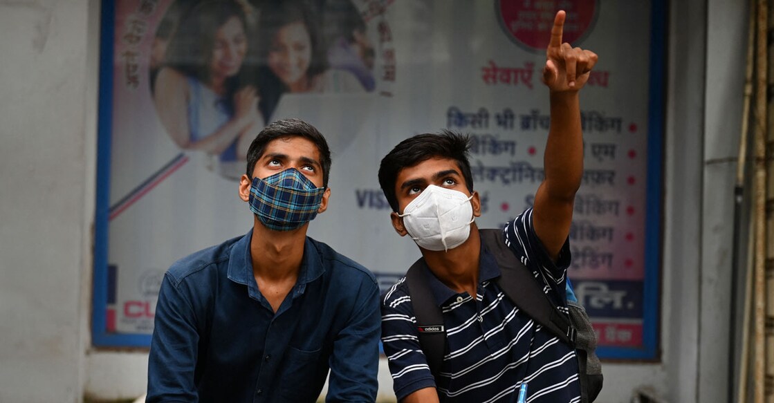 INDIA-ECONOMY-STOCKS Pedestrians watch share prices on a digital broadcast as they stand outside the Bombay Stock Exchange (BSE) in Mumbai on September 24, 2021. (Photo by Punit PARANJPE / AFP)
