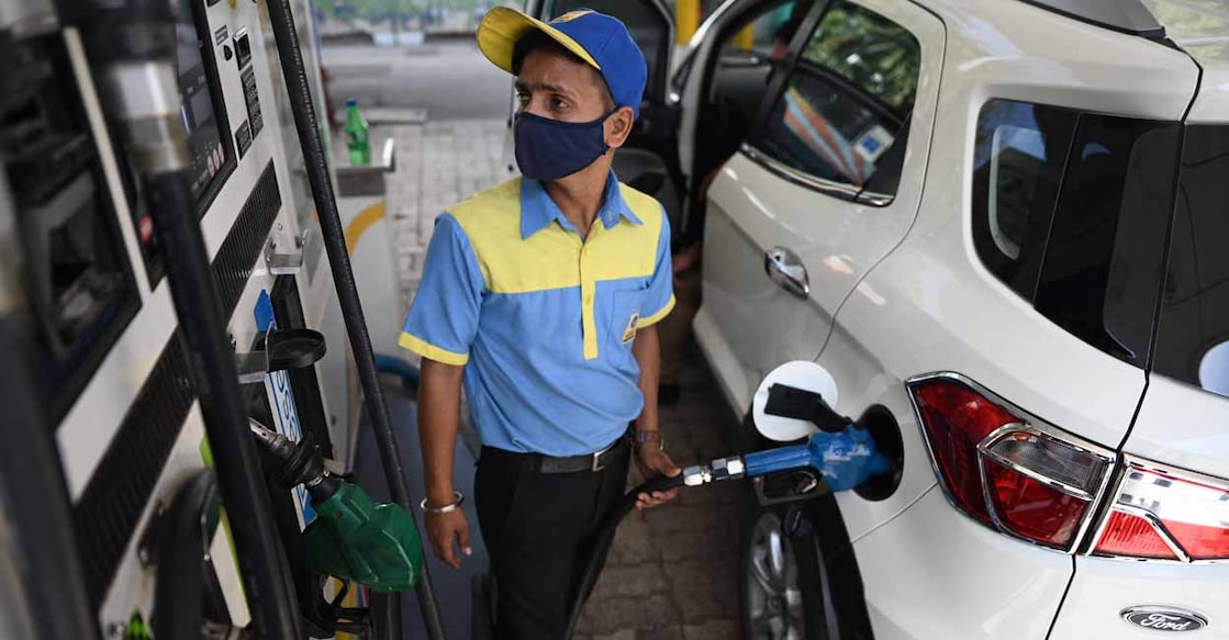 A worker fills up the tank of a car with diesel at a petrol station in New Delhi on October 23, 2021 following a price hike of fuel and diesel. (Photo by Sajjad HUSSAIN / AFP)