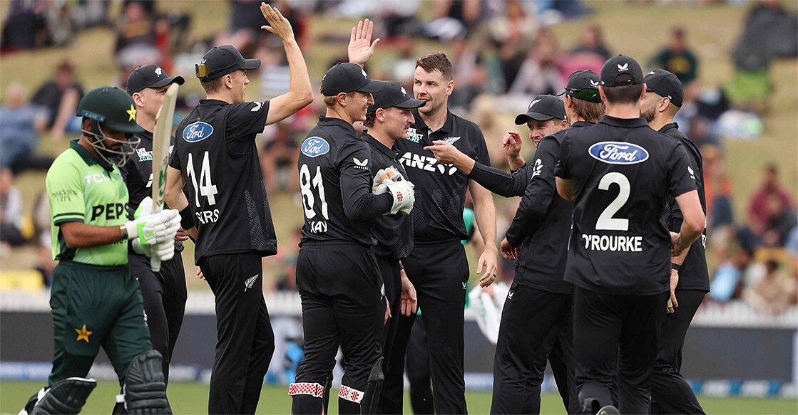 പാക്കിസ്ഥാൻ താരം ബാബർ അസം പുറത്തായി മടങ്ങുമ്പോൾ വിക്കറ്റ് നേട്ടം ആഘോഷിക്കുന്ന ന്യൂസീലൻഡ് താരങ്ങൾ (Photo by Michael Bradley / AFP)