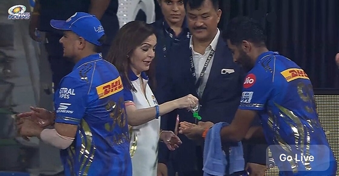 ജസ്പ്രീത് ബുമ്രയുടെ കൈകളിലേക്ക് സാനിറ്റൈസർ ഒഴിച്ചുകൊടുക്കുന്ന നിത അംബാനി (എക്സിൽ പ്രചരിക്കുന്ന ചിത്രം)